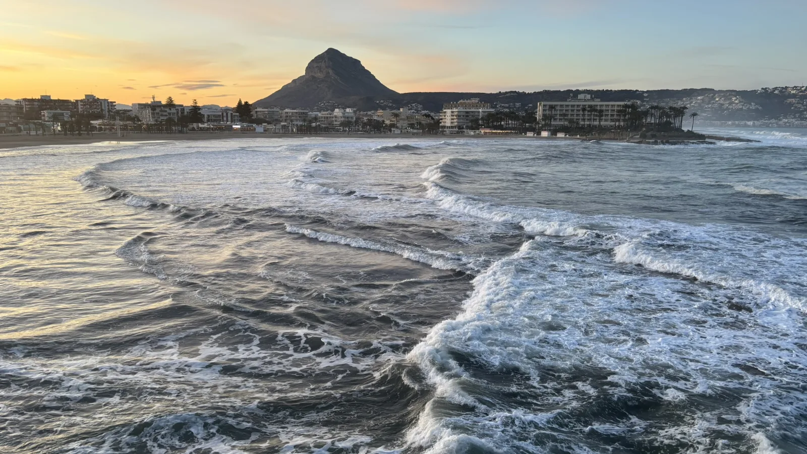 Oleaje frente a la playa del Arenal con el Montgó recortado al atardecer
