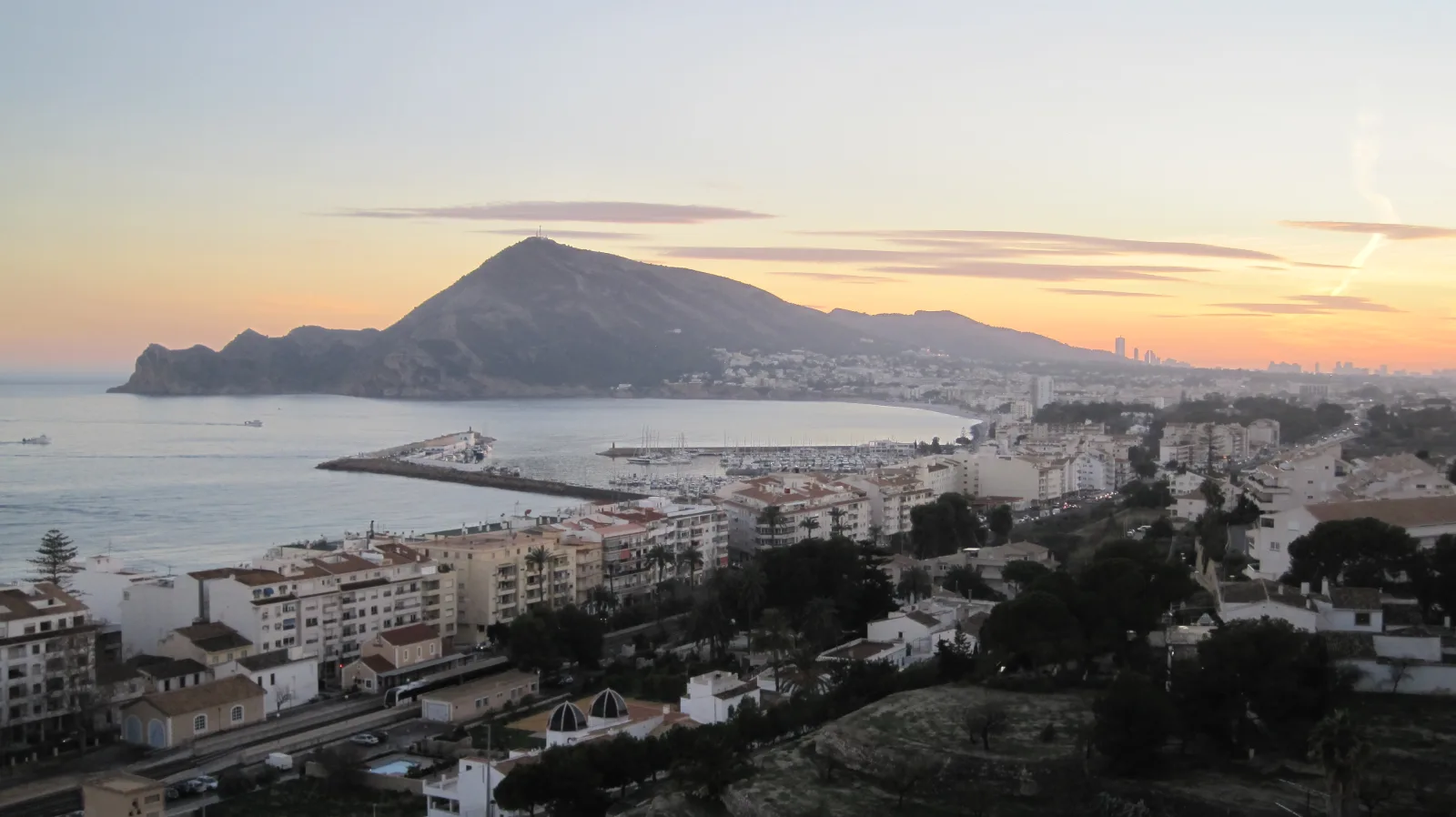 Vista de la costa de l’Albir y Altea al atardecer, con edificios, puerto y Serra Gelada